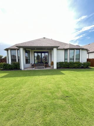 A charming modern home with a lush green lawn in Devonshire by Highland Homes (Forney, TX).