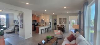 A bright, open-concept living space in a Marbella home, featuring a modern kitchen with an island, a comfortable living room with a sofa, and ample natural light (San Antonio, TX).