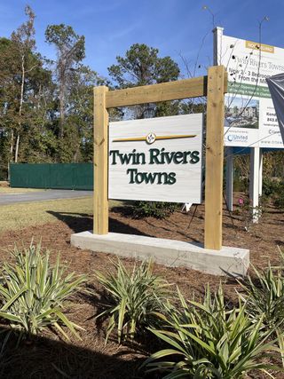 Street view A welcoming entry sign amidst lush landscaping at Twin Rivers Towns by Prosperity Builders (Charleston, SC).