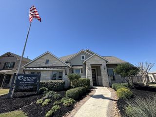 A charming stone-accented home with manicured landscaping in Foxbrook by Coventry Homes (Cibolo, TX).