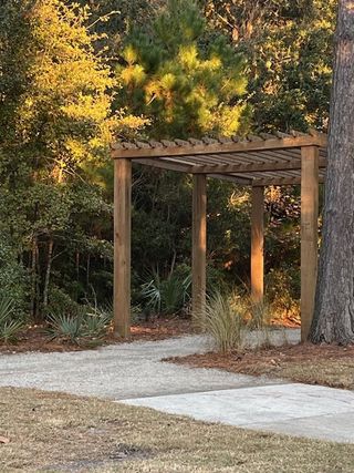 A peaceful outdoor pergola surrounded by nature in Liberty Hill Farm by K. Hovnanian® Homes (Mount Pleasant, SC).
