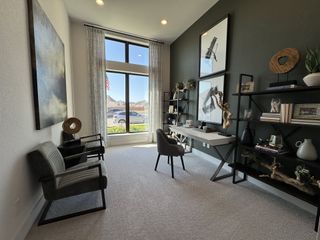 A modern study with elegant decor, featuring large windows, stylish shelving, and plush seating.