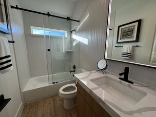 A sleek bathroom featuring a modern vanity, glass shower doors, and elegant wall tiles.