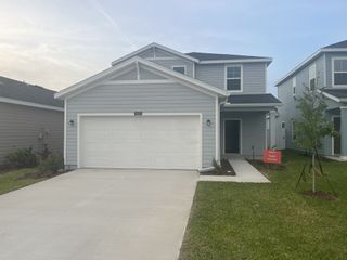 A charming gray home with a white garage and neat lawn in Marion Ranch: Marion Ranch 60's by Lennar (Ocala, FL).