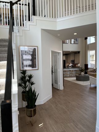 A contemporary interior featuring an elegant staircase, open floor plan, and stylish decor with natural wood flooring.