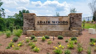 A welcoming entrance sign with landscaped greenery in Adair Woods by D.R. Horton (Davidson, NC).
