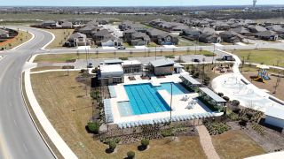 A vibrant community pool with modern facilities in Steele Creek by D.R. Horton, Cibolo, TX, surrounded by scenic homes.