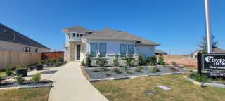 Street view A modern stone-accented home with landscaped garden in Megan's Landing 50' Homesites by Coventry Homes (Castroville, TX).