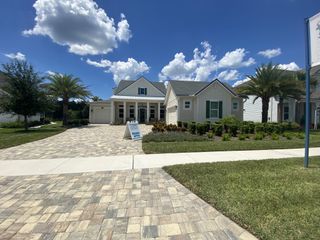 Charming white home with lush landscaping and palm trees in Courtney Oaks at SilverLeaf by Riverside Homes (St. Augustine, FL).