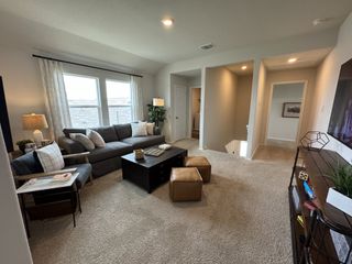 A cozy loft space with a plush sectional, stylish decor, and large windows letting in natural light, perfect for relaxation