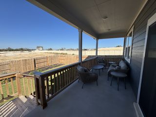 Model Home A cozy covered patio with comfortable seating and scenic views, perfect for relaxing or entertaining.