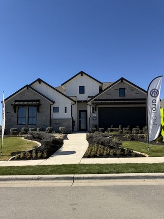Street view A modern home with clean lines and a landscaped path in Santa Rita Ranch by GFO Home (Liberty Hill, TX).