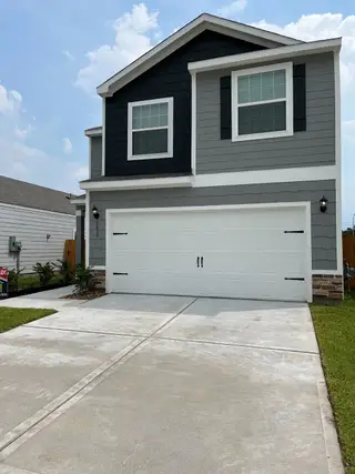 A modern two-story home with a sleek design and spacious driveway in Park Vista at El Tesoro by LGI Homes (Houston, TX).