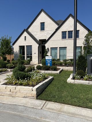 A charming white brick home with manicured gardens in Marvida 45' - Gated by Perry Homes (Cypress, TX).