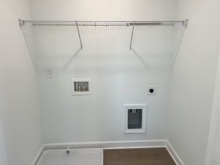 A functional laundry nook with wall shelving and hookups awaits in this modern home.