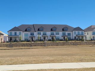 Street view Modern townhomes with manicured lawns in Village on Main Street by Normandy Homes (Frisco, TX).
