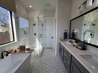 Model Home A spa-like bathroom with a freestanding tub, glass-enclosed shower, and black fixtures adding a modern flair.