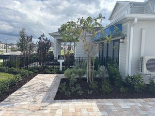 A charming home with landscaped yard and brick path in Trailside by DRB Homes (Mount Dora, FL).