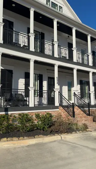 Street view A charming multi-level white façade with balconies in Reserve in Memorial by Sullivan Brothers Builders (Houston, TX).