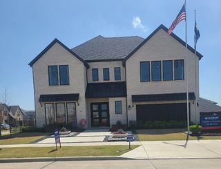 Street view A modern white brick home with dark accents, nestled in Estates at Rockhill by Windsor Homes (Frisco, TX).