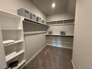 A spacious walk-in closet featuring shelves, hanging space, and stylish storage bins for organized convenience.