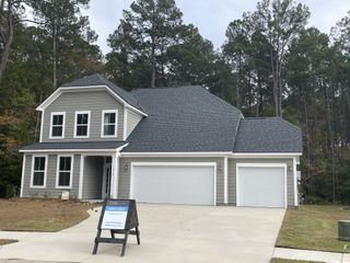 Street view A charming gray home with a spacious three-car garage at Enclave at South Pointe Estates by DRB Homes (Summerville, SC).
