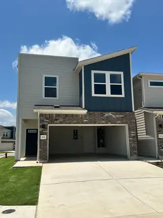 Street view Modern two-story home with a mix of brick and siding in Homestead Village by Meritage Homes (Round Rock, TX).