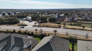 A stunning aerial view of the Palmera Ridge community by Highland Homes, offering peaceful streets, scenic homes, and breathtaking natural beauty in Leander, TX.