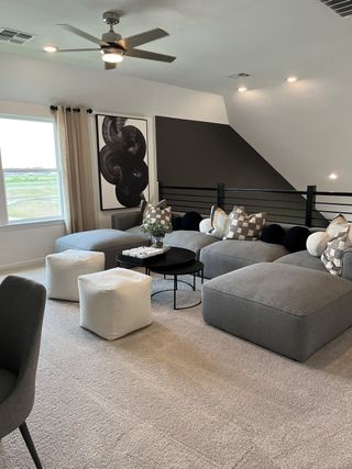 A cozy living space featuring plush gray seating, abstract art, and modern accents, perfect for relaxation and style.