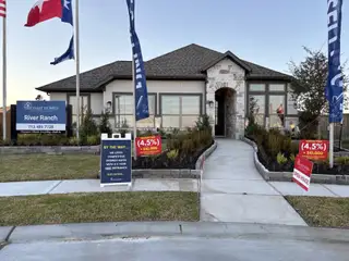 Street view A charming stone-accented home with manicured landscaping in River Ranch 50' & 55' by Tricoast Homes (Dayton, TX).