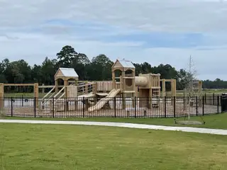 Community Amenities A delightful community playground with wooden structures and slides in Hewing Farms by Mungo Homes (Summerville, SC).