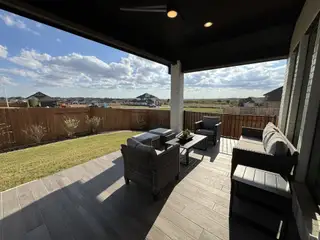 Model Home Covered Patio: A serene covered patio with cozy seating and scenic views.