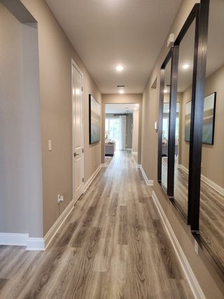 A modern hallway with sleek wood flooring, neutral tones, and elegant recessed lighting.