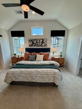 Model Home A cozy bedroom with vaulted ceilings, modern fan, abstract art, and serene decor.