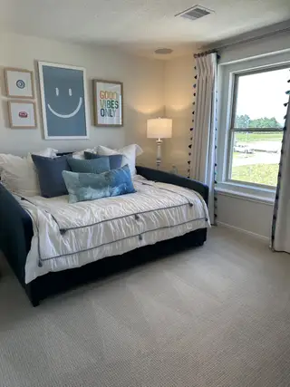 A cozy bedroom with a daybed, cheerful wall art, and soft lighting, offering a calming and inviting atmosphere.