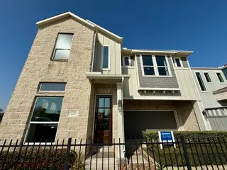 Street view A modern two-story home with stone and siding exterior in Spring Brook Village by Meritage Homes (Houston, TX).