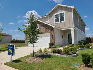 Model Home A charming two-story home with a manicured lawn in Coyote Meadows by Starlight Homes (Anna, TX).