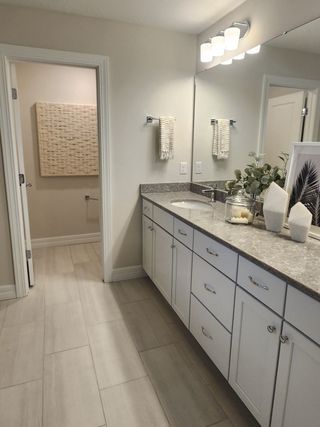 Model Home A modern double vanity bathroom with sleek countertops, large mirrors, and neutral decor.