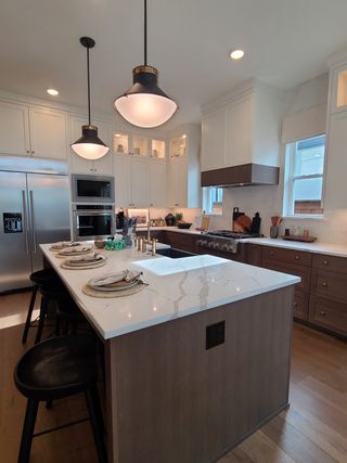 A modern kitchen with sleek pendant lighting, a spacious island, and elegant cabinetry creating a sophisticated atmosphere.