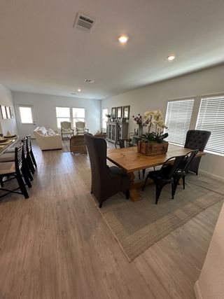 An inviting open-concept living area with modern furnishings, wooden floors, and natural light streaming through windows.