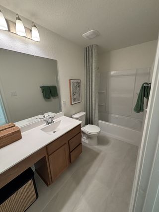 A modern bathroom with a sleek vanity, large mirror, and elegant shower curtain.