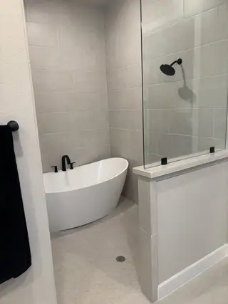 A spa-like retreat featuring a sleek freestanding tub, glass-enclosed shower, and modern tile finishes for ultimate relaxation.