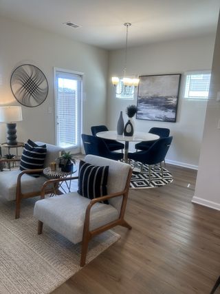 A modern dining and living area with elegant decor, wood flooring, and chic furniture, creating a cozy, stylish ambiance.