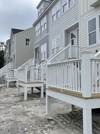 Elegant townhomes with crisp white railings and modern siding in Cooper River Townes by DRB Homes (North Charleston, SC).
