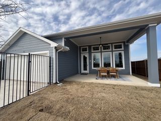 A modern blue home with a fenced yard and cozy patio in Midtowne by William Ryan Homes (Midlothian, TX).