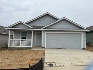 A modern gray home with a cozy front porch and two-car garage in Sage Meadows by Lennar (St. Hedwig, TX).