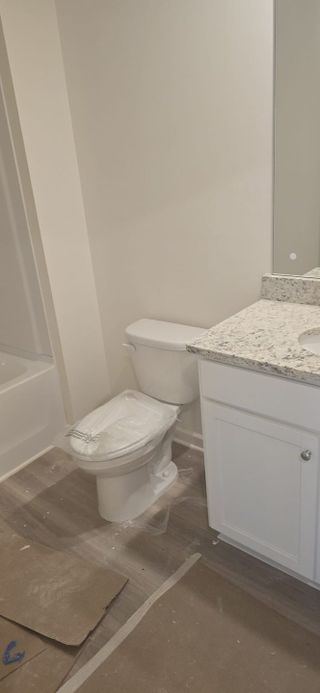A modern bathroom featuring a polished granite countertop, white cabinetry, and sleek fixtures.
