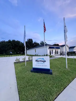 A welcoming sales center with flag display in Lakes at Bella Lago - Signature Series by Meritage Homes (Green Cove Springs, FL).