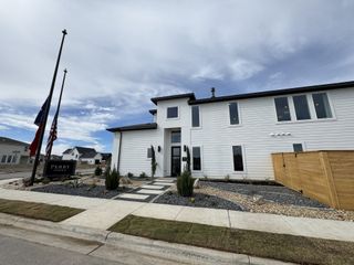 A modern white home with sleek lines and landscaped entry in Solms Landing 45' by Perry Homes (New Braunfels, TX).