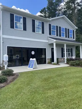 Charming two-story home with black shutters and front columns in Petterson Meadows by Mungo Homes (Summerville, SC).